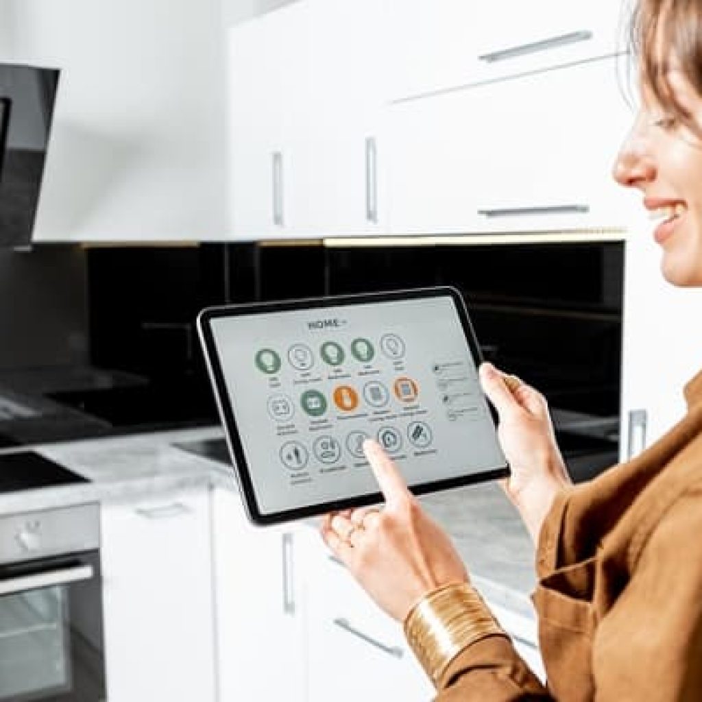 Woman Is Using A Tablet To Control Kitchen Appliances.