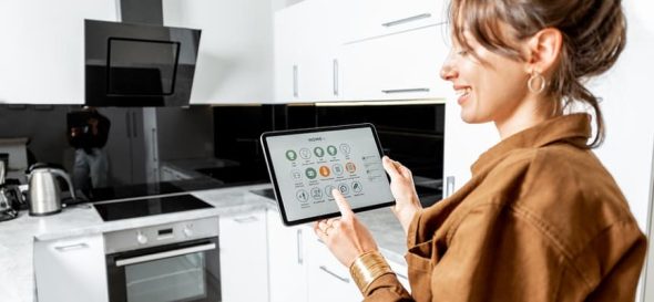 Woman Is Using A Tablet To Control Kitchen Appliances.
